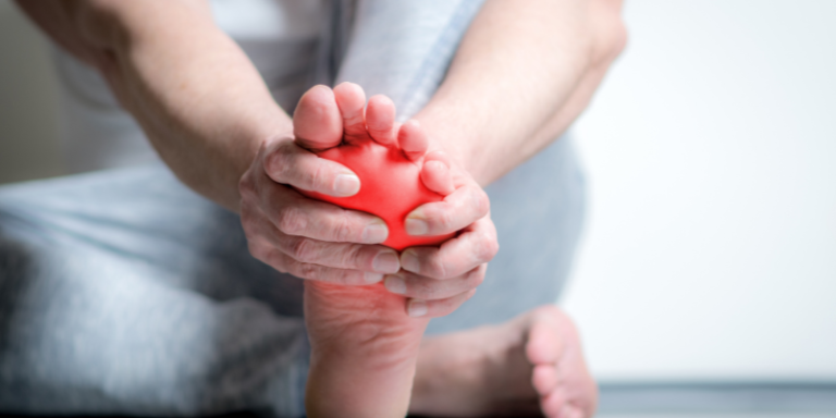 Person grabbing their foot because it hurts
